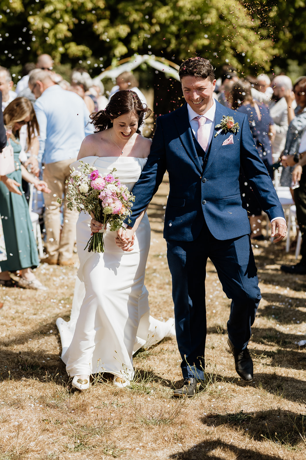 Loose, garden-inspired bridal bouquet with roses, soft greenery and flowing ribbons at Battleswick Farm